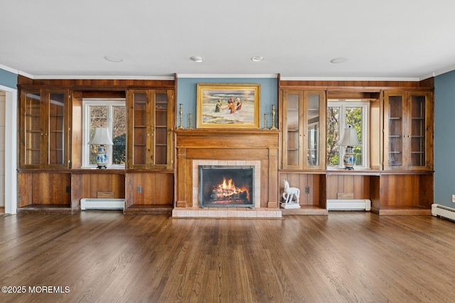 unfurnished living room with crown molding, baseboard heating, and wood finished floors