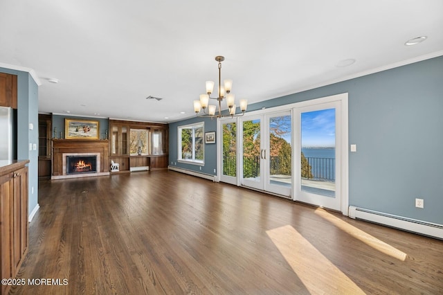 unfurnished living room featuring dark wood-style floors, a baseboard radiator, a notable chandelier, and a lit fireplace