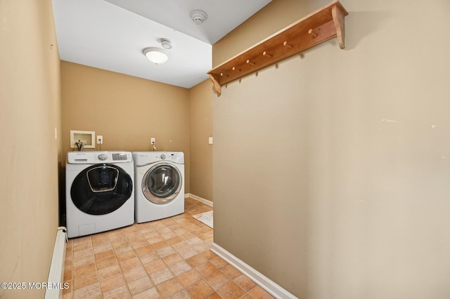 laundry room featuring laundry area, stone finish floor, washing machine and dryer, and baseboards