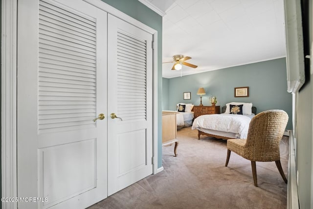 carpeted bedroom featuring ceiling fan and ornamental molding