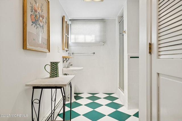 full bathroom featuring a stall shower, a sink, and tile patterned floors