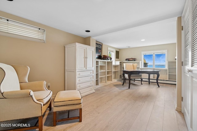 sitting room with light wood finished floors, baseboard heating, and recessed lighting