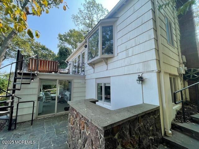 back of property featuring a patio area and stairs