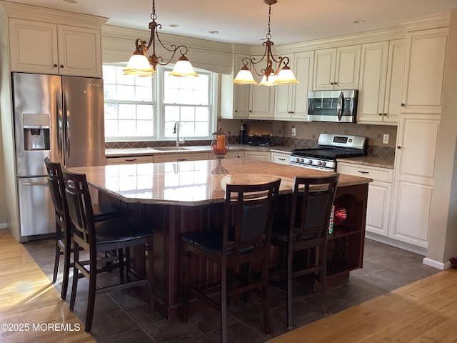 kitchen with appliances with stainless steel finishes, a sink, and a center island