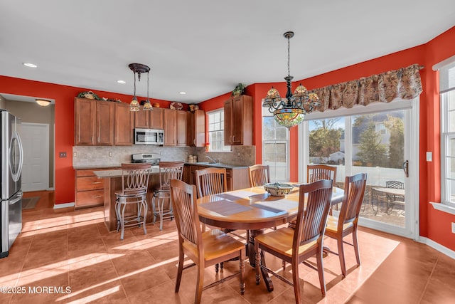 dining room featuring a notable chandelier, baseboards, light tile patterned flooring, and recessed lighting