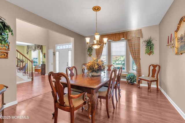 dining room featuring a notable chandelier, plenty of natural light, and wood finished floors