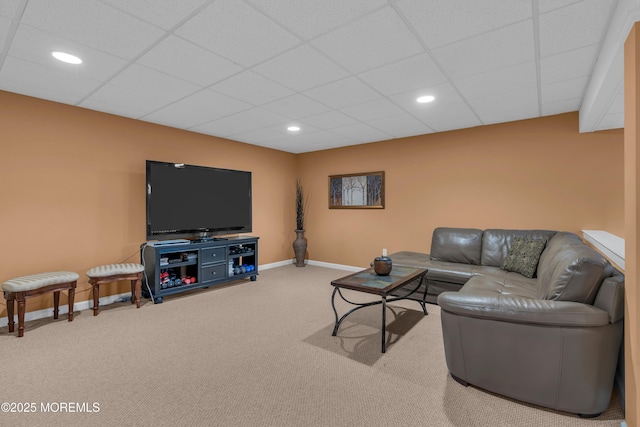 carpeted living room featuring baseboards, recessed lighting, and a drop ceiling