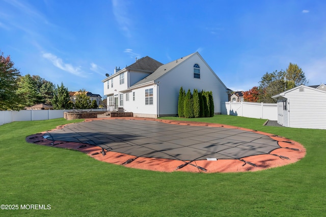 back of house featuring a lawn, a fenced in pool, and a fenced backyard