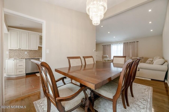 dining area with recessed lighting, an inviting chandelier, and light wood-style floors