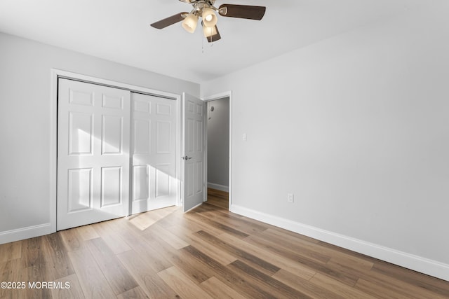 unfurnished bedroom with baseboards, a ceiling fan, a closet, and light wood-type flooring