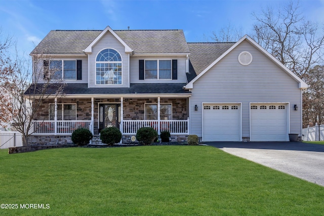 view of front of property with a porch, an attached garage, fence, driveway, and a front lawn