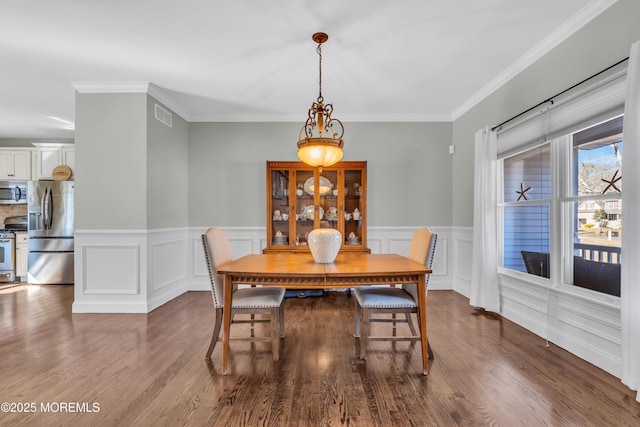 dining area with visible vents, wood finished floors, and ornamental molding