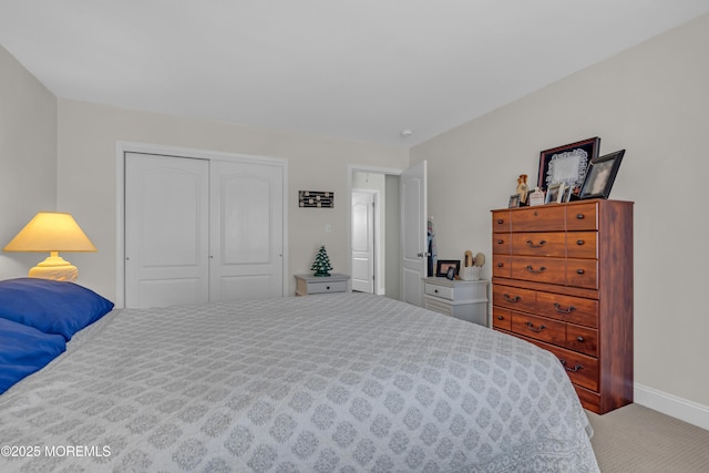 carpeted bedroom featuring a closet and baseboards