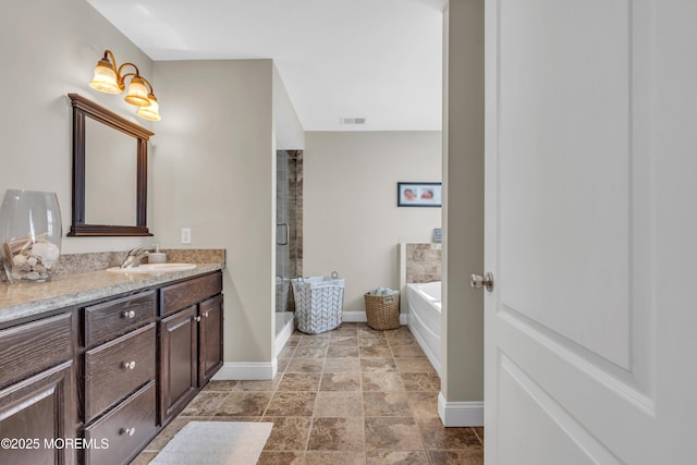 bathroom featuring a garden tub, vanity, visible vents, baseboards, and a shower stall