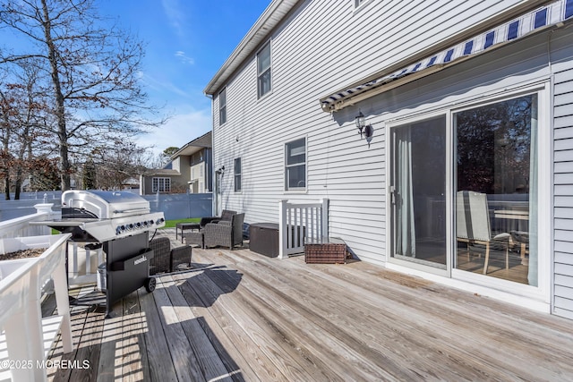 deck with a grill and fence