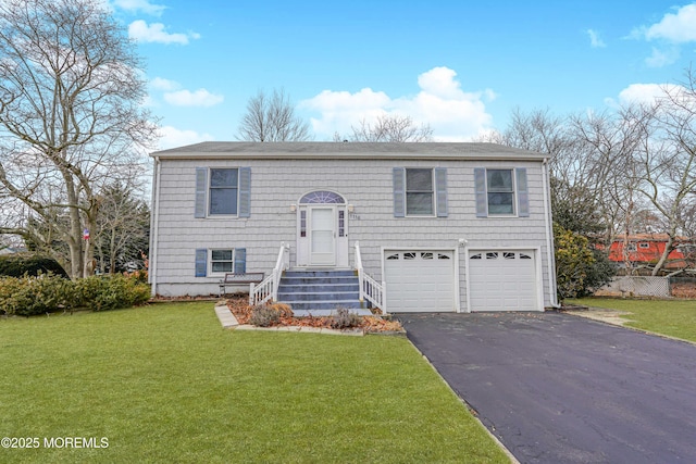 split foyer home featuring an attached garage, aphalt driveway, and a front yard