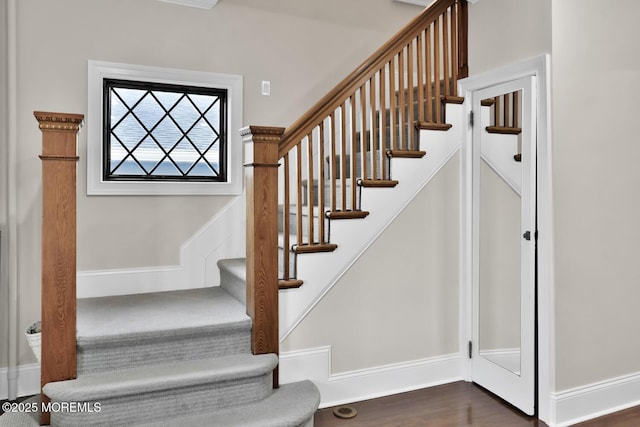 stairs with baseboards and wood finished floors