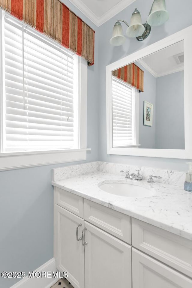 bathroom with ornamental molding, vanity, and a wealth of natural light