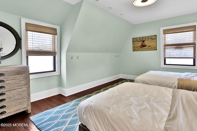 bedroom with dark wood-style floors, lofted ceiling, and baseboards