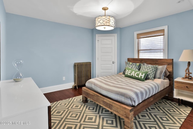 bedroom with baseboards, wood finished floors, and radiator