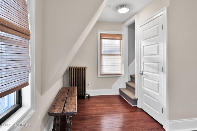 stairway featuring baseboards, wood finished floors, and radiator