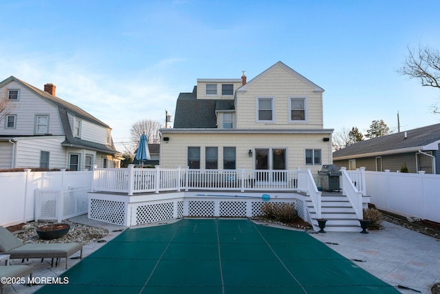 rear view of house with a deck, a shingled roof, and a fenced backyard