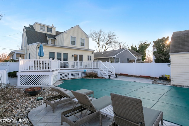 back of property with a shingled roof, a patio area, a fenced backyard, and a wooden deck