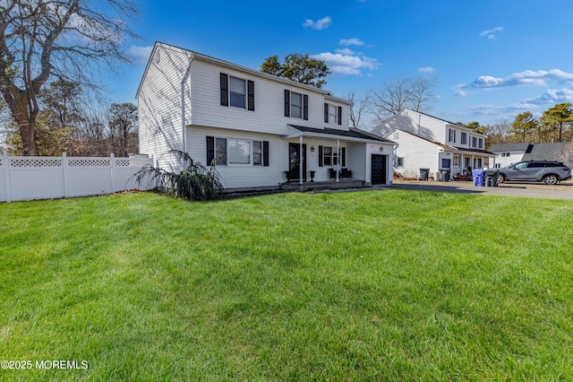 view of front of home with a garage, driveway, a front yard, and fence