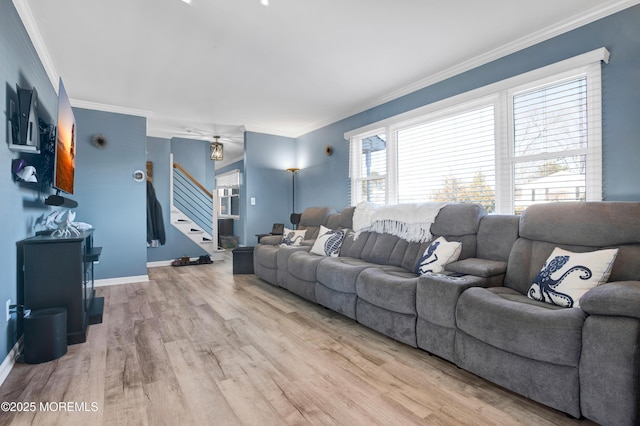 living area with light wood-style flooring, crown molding, stairway, and baseboards