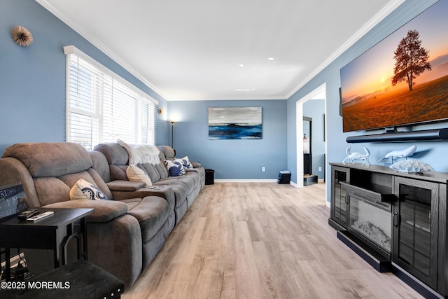 living area featuring light wood-style flooring, baseboards, and crown molding