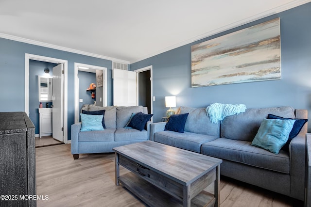 living room featuring crown molding and light wood finished floors