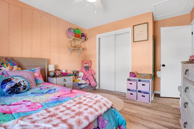 bedroom featuring light wood-style floors, attic access, a closet, and a ceiling fan