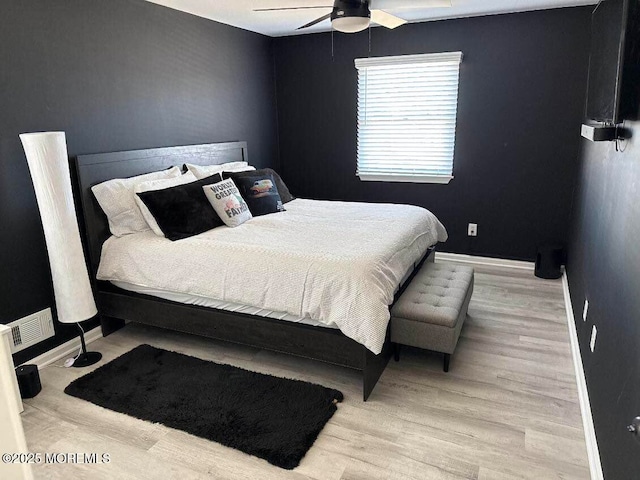 bedroom featuring ceiling fan, light wood-style flooring, and baseboards