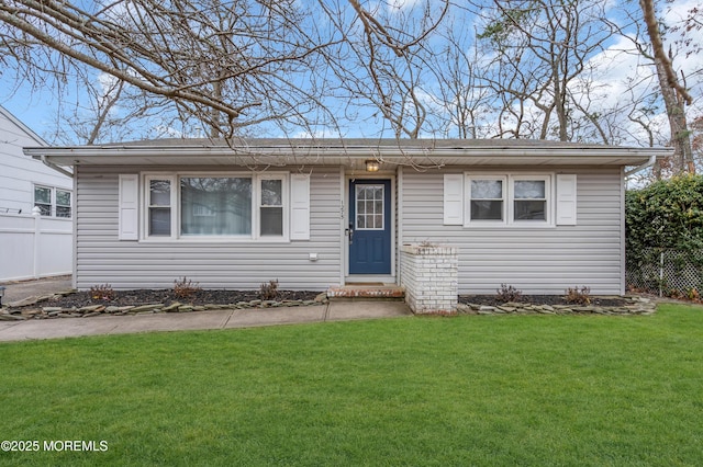 view of front facade featuring a front lawn and fence