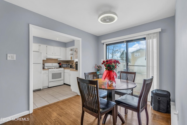 dining space with light wood-style floors and baseboards