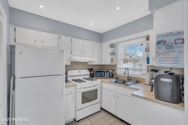 kitchen with light countertops, white cabinetry, a sink, white appliances, and under cabinet range hood