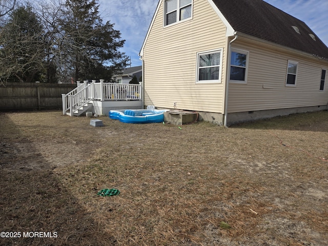 view of property exterior with crawl space, a shingled roof, fence, and a wooden deck