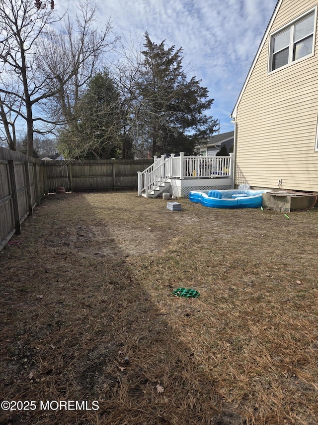 view of yard featuring a fenced backyard and a wooden deck