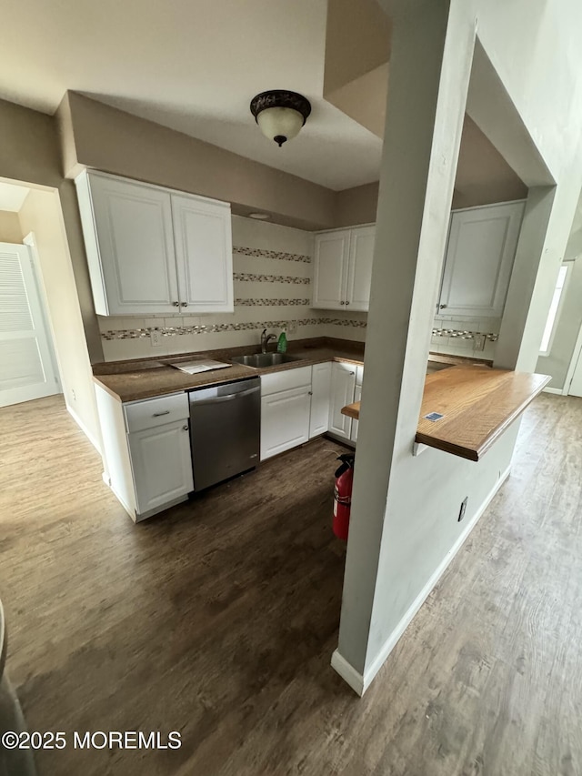 kitchen with dark wood finished floors, decorative backsplash, white cabinetry, a sink, and dishwasher