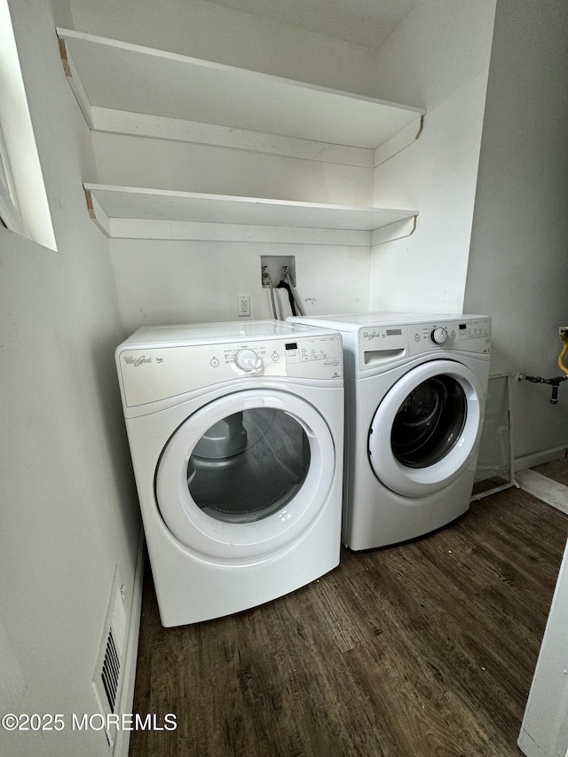 clothes washing area featuring dark wood-style floors, laundry area, visible vents, and independent washer and dryer