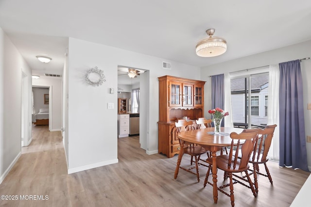 dining area featuring ceiling fan, light wood finished floors, visible vents, and baseboards