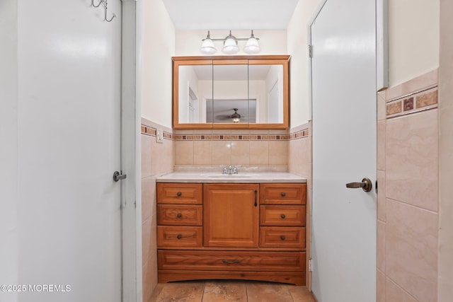 bathroom with a wainscoted wall, vanity, and tile walls