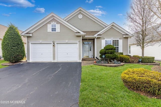 view of front of house featuring a garage, a front yard, and driveway