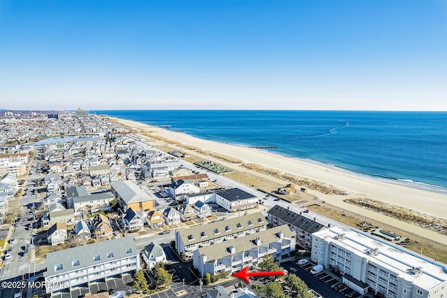 birds eye view of property featuring a water view, a beach view, and a city view