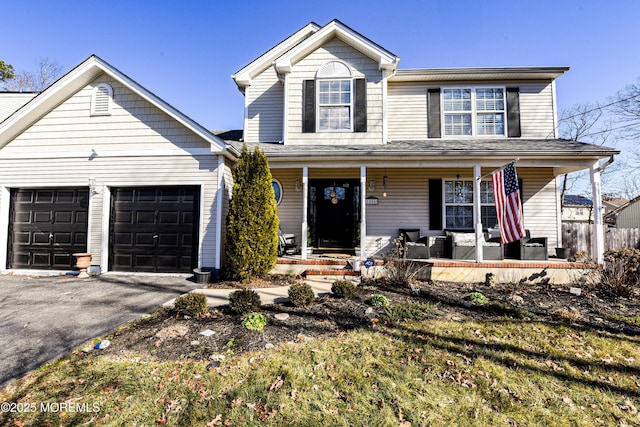 traditional-style home featuring driveway, a porch, and an attached garage