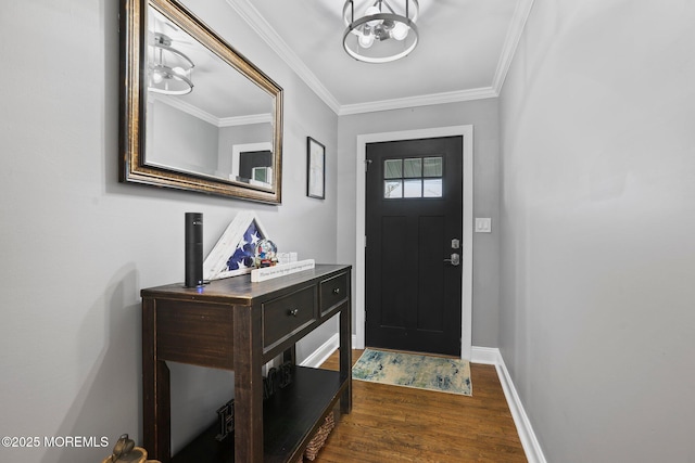 entryway featuring baseboards, dark wood-type flooring, an inviting chandelier, and crown molding