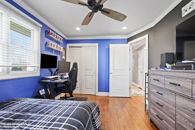 bedroom with a ceiling fan, baseboards, wood finished floors, ornamental molding, and a closet