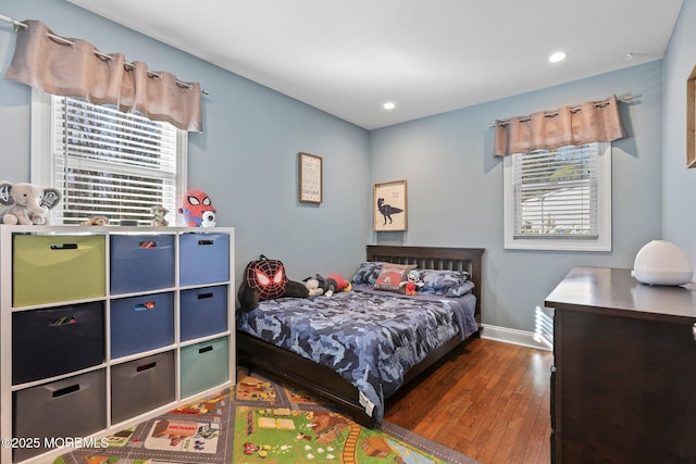 bedroom with recessed lighting, baseboards, multiple windows, and wood finished floors