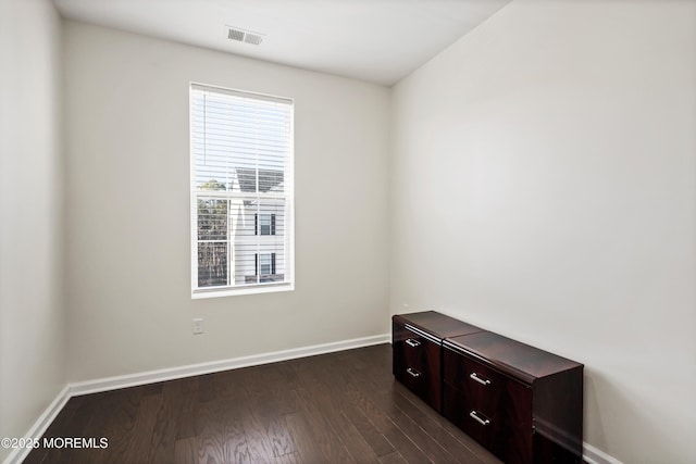 spare room with dark wood-style floors, baseboards, and visible vents