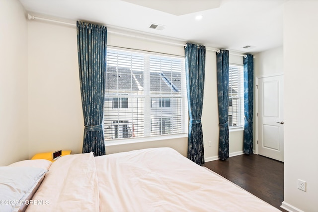 bedroom featuring dark wood-style flooring, visible vents, and baseboards